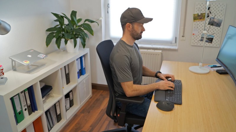 Person zeigt die ergonomische Sitzhaltung mit dem ergonomischen Bürostuhl Interstuhl PURE Fashion