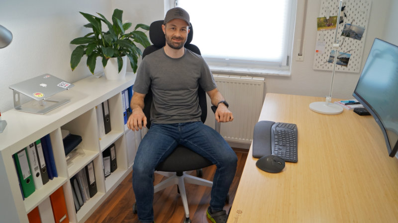 Person sitzt am Schreibtisch auf dem Ergotopia MasterBack (Test)