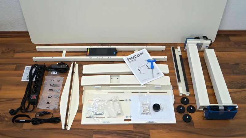 Einzelteile des FlexiSpot E7 Flow liegen sortiert auf dem Boden