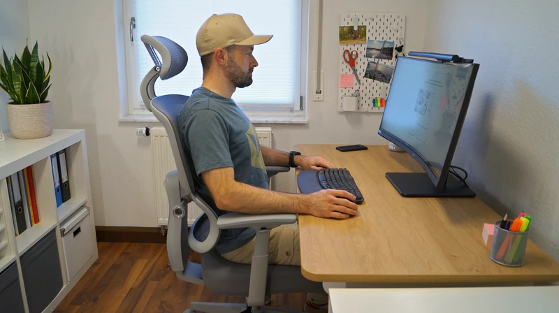 Person sitzt am Schreibtisch auf dem DESKSPACE Move und zeigt ergonomische Sitzposition