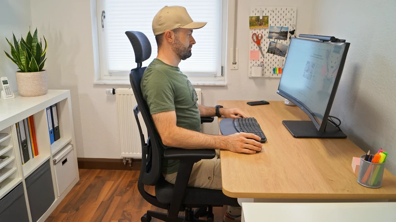 Person sitzt auf dem Ergotopia PureBack und zeigt ergonomische Sitzposition