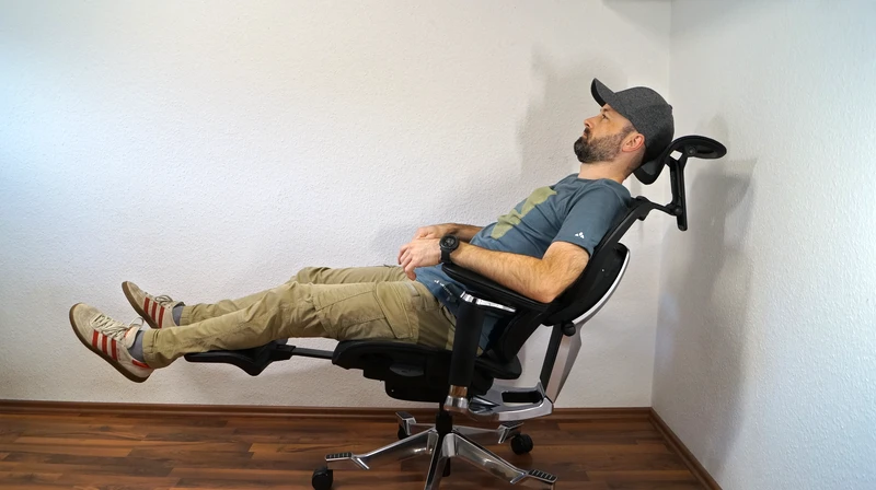 Person zeigt Liegeposition auf dem FlexiSpot C7 Morpher, ausgefahrene Fußstütze