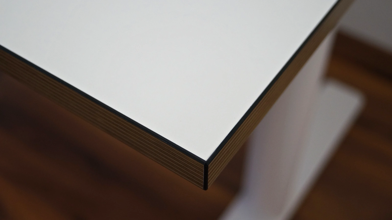 Blick auf die Tischkante der weißen Eliot-Tiny-Tischplatte
